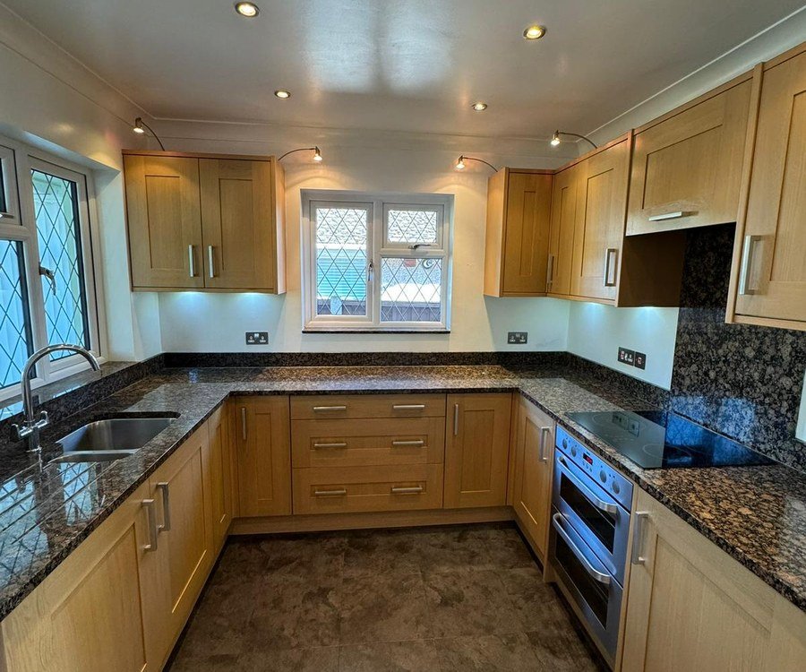 Kitchen with original oak units before spray painting, granite worktop