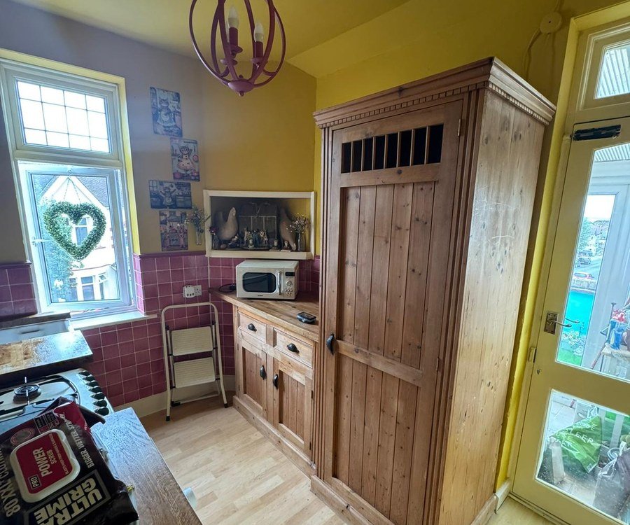 Kitchen with bare pine larder cupboard before spray painting