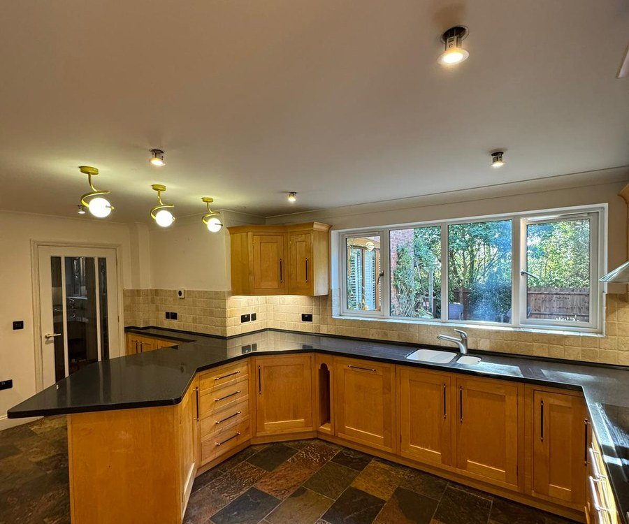 Kitchen with original oak units before spray painting, slate tiled floor
