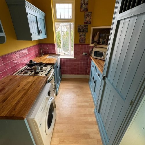 Kitchen units spray painted in blue-grey with solid wood worktop