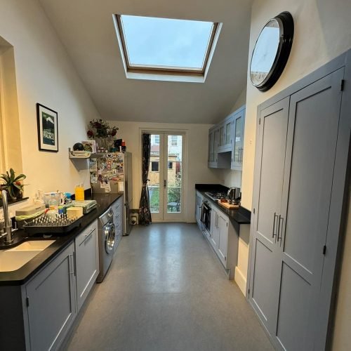 Galley kitchen units spray painted in soft grey