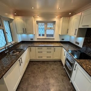 Cream resprayed kitchen with granite worktop, front view