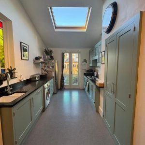 Galley kitchen with units spray painted in soft grey, after respray